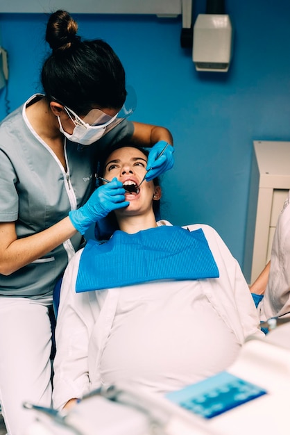 Dentista che opera una donna incinta in una clinica medica
