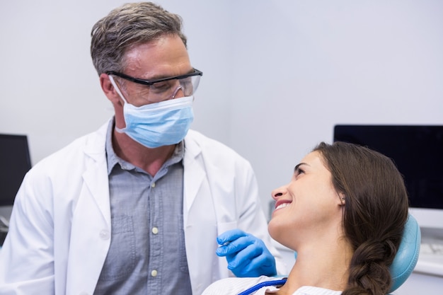 Dentista che parla con la donna alla clinica