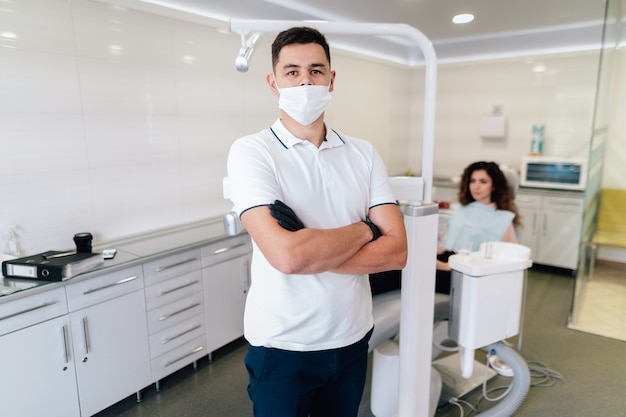 Dentista che posa nell'ufficio con il paziente