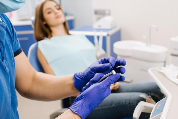 Dentista che prepara trapano per il trattamento del primo piano