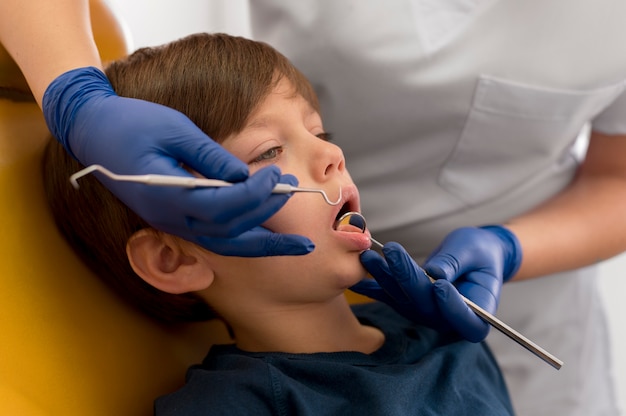 Dentista che pulisce i denti del bambino