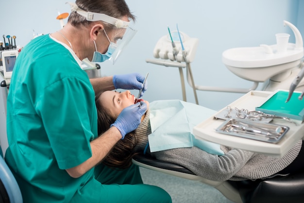 Dentista con le mani guantate che tratta un paziente