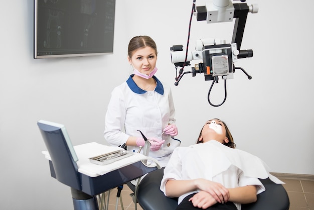 Dentista della donna con il paziente allo studio dentistico