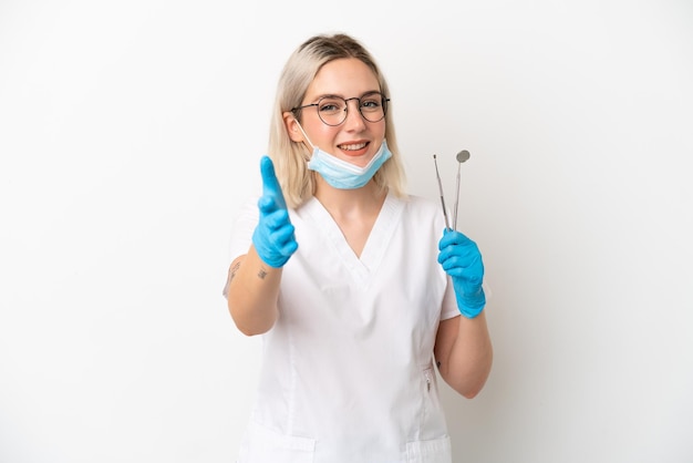 Dentista donna caucasica che tiene strumenti isolati su sfondo bianco stringe la mano per chiudere un buon affare