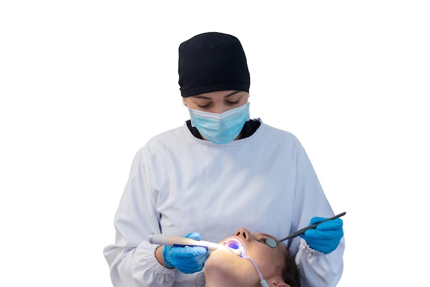Dentista donna in uniforme e maschera facciale durante un intervento dentale su un paziente Concetto di clinica dentale
