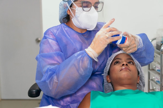 Dentista donna latina che cura un paziente