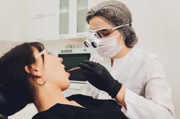 Dentista e paziente che scelgono il trattamento in una consultazione con apparecchiature mediche in background