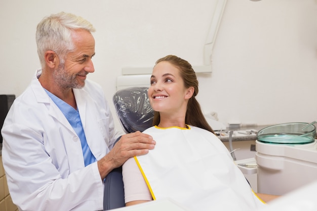 Dentista e paziente che sorridono a vicenda