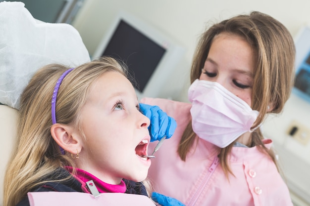 Dentista e paziente delle bambine durante l&#39;esame dentario.