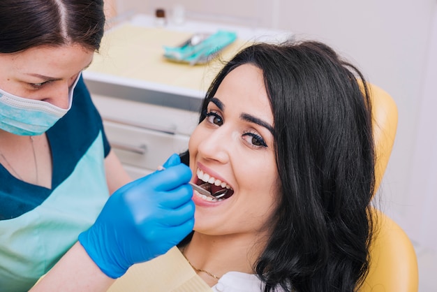 Dentista esaminando i denti del paziente felice