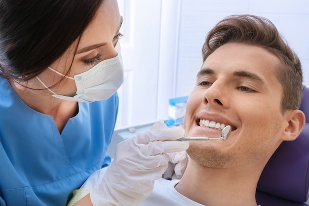 Dentista esaminando i denti del paziente in clinica