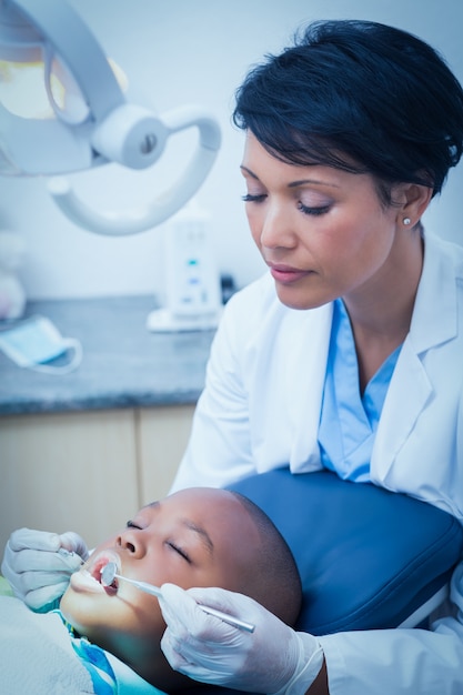 Dentista femminile che esamina i denti dei ragazzi