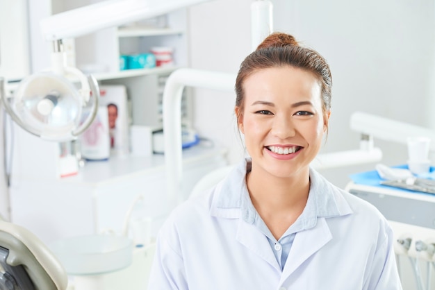 Dentista femminile che sorride alla macchina fotografica