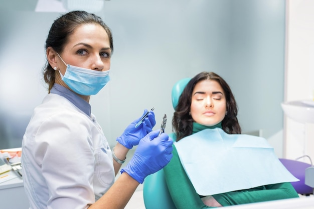 Dentista femminile che tiene le pinze