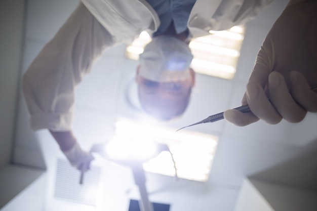 Dentista femminile che tiene strumento dentale