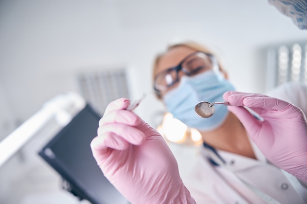 Dentista femminile che utilizza strumenti durante il trattamento del paziente
