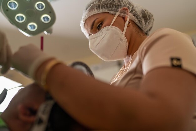 Dentista femminile con maschera e cappuccio protettivo funzionante