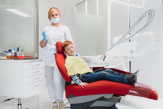 Dentista femminile e bambino in uno studio dentistico