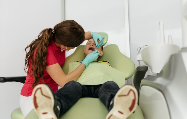 Dentista femminile e bambino in uno studio dentistico