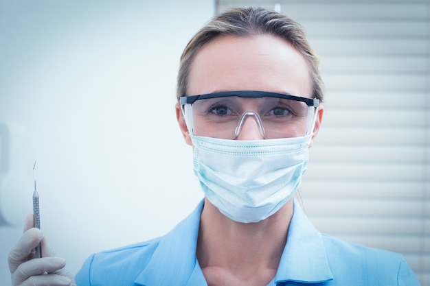 Dentista femminile nell&#39;iniezione della tenuta della maschera chirurgica