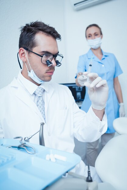 Dentista guardando iniezione