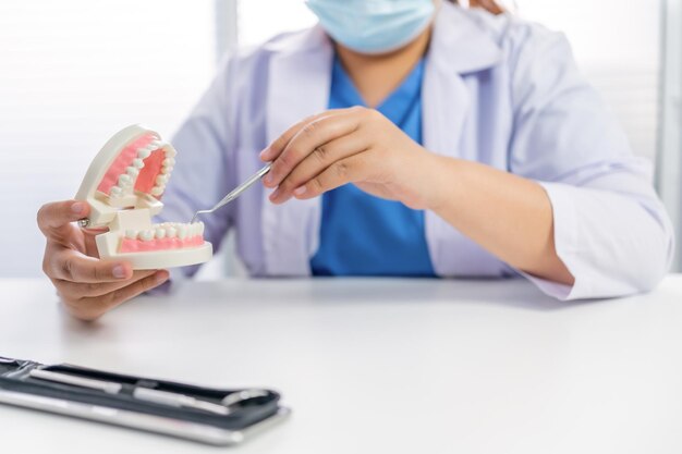 Dentista in clinica dentale Dente sano bianco con modello dentale nei chirurghi orali che discutono la radiografia della mascella su pillola medicina assistenza sanitaria concetto di chirurgia orale