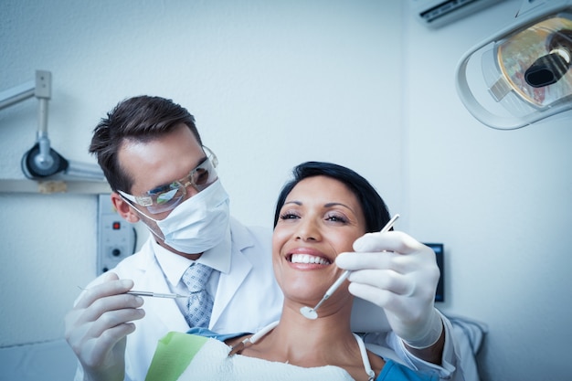 Dentista maschio che esamina i denti dei womans