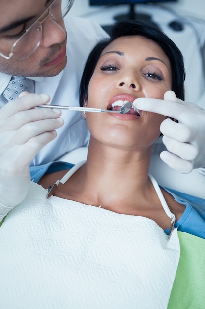 Dentista maschio che esamina i denti dei womans