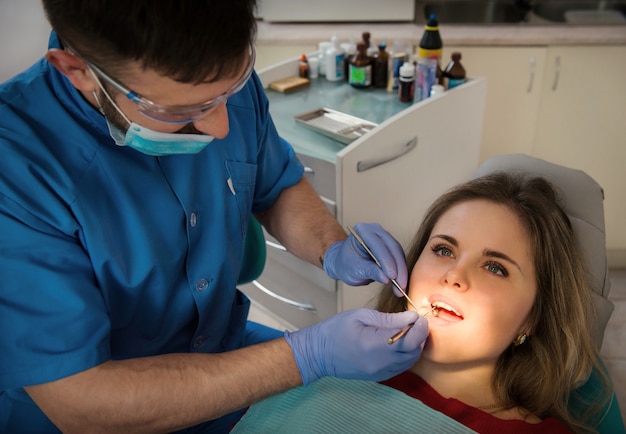 Dentista maschio che esamina i denti di una donna