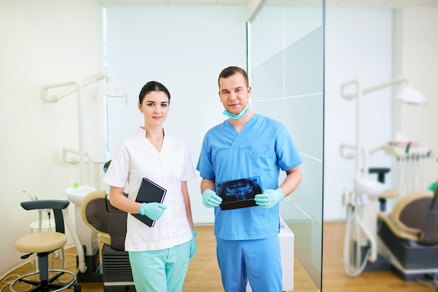 Dentista maschio e assistente donne sul posto di lavoro uno studio dentistico