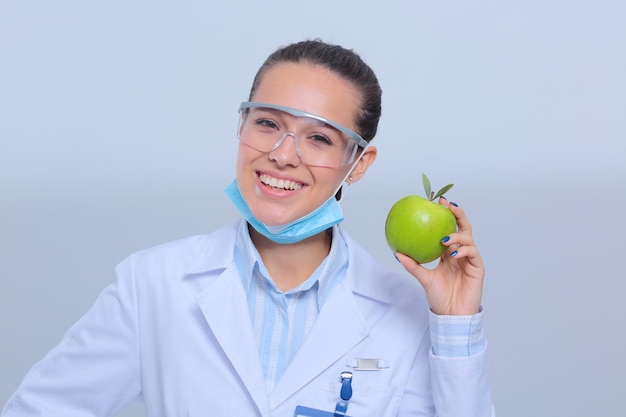 Dentista medico donna tenere verde mela fresca in mano e spazzolino da denti Medici dentisti Medici donna