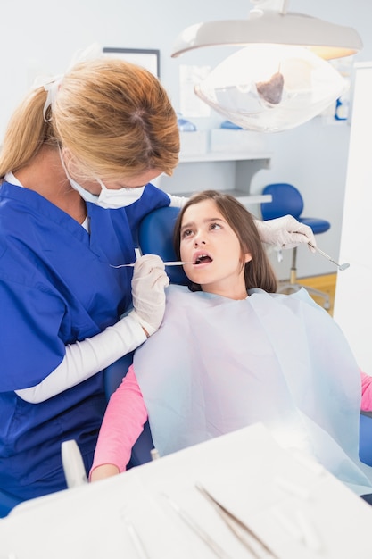 Dentista pediatrico che esamina il suo giovane paziente