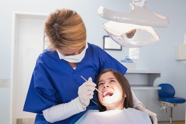 Dentista pediatrico che esamina il suo giovane paziente