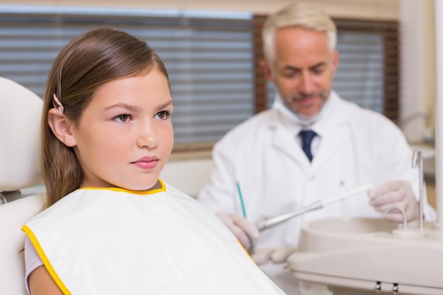 Dentista pediatrico e bambina che si siedono nella sedia