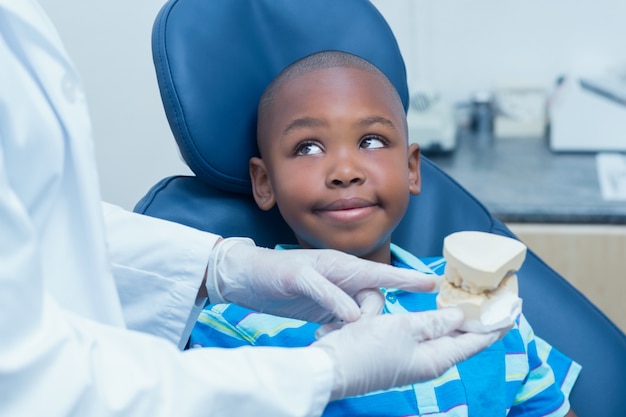 Dentista potato che mostra i denti della protesi del ragazzo