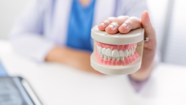 Dentista presso la clinica odontoiatrica Dente sano bianco con modello dentale in chirurghi orali che discutono dei raggi x della mascella sul concetto di chirurgia orale sanitaria della medicina tablet