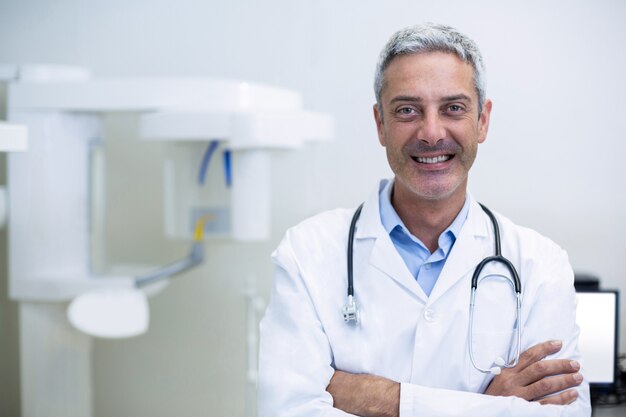 Dentista sorridente che sta nella clinica dentale