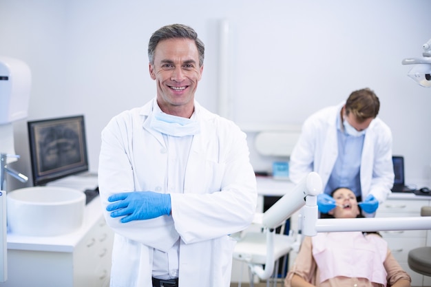 Dentista sorridente in piedi con le braccia incrociate