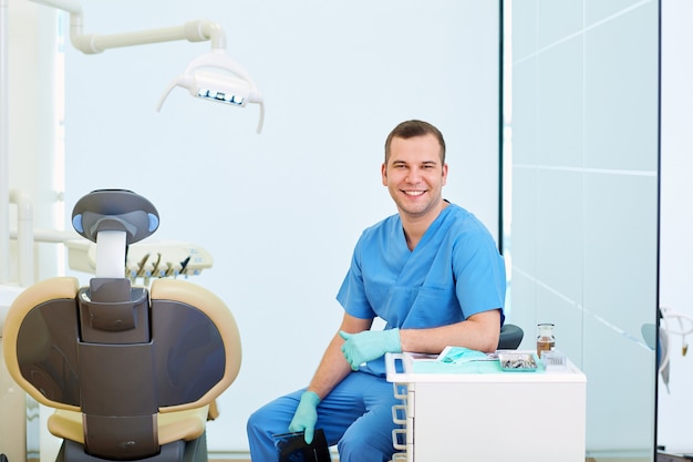 Dentista sorridente uomo seduto in ufficio