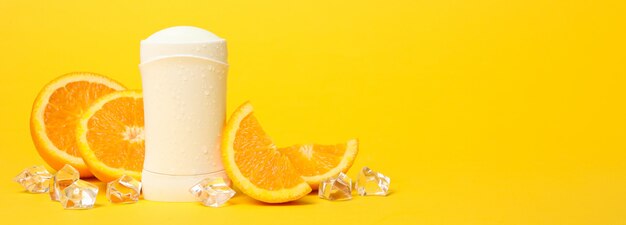 Deodorante per il corpo, ghiaccio e arancio su giallo