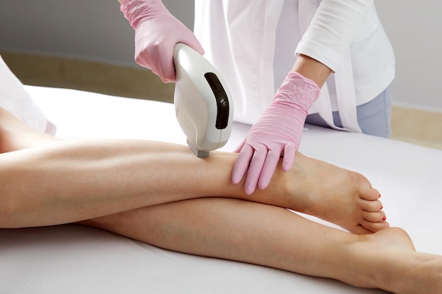 Depilazione laser sulle gambe delle donne nel salone di bellezza