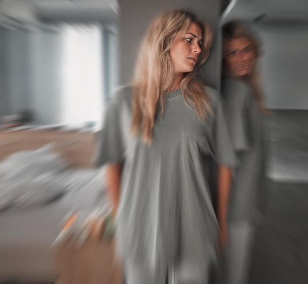 Depressione bipolare e giovane donna spaventata in una camera da letto con preoccupazione, paura e stress Insonnia problema di salute mentale e paziente dolorante con ansia da movimento sfocato e schizofrenia all'ospedale psichiatrico