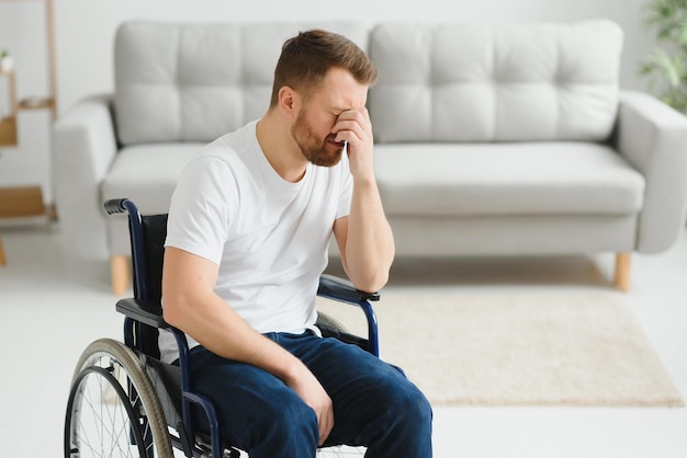 Depressione e solitudine nell'uomo disabile Uomo anziano in sedia a rotelle che piange all'interno