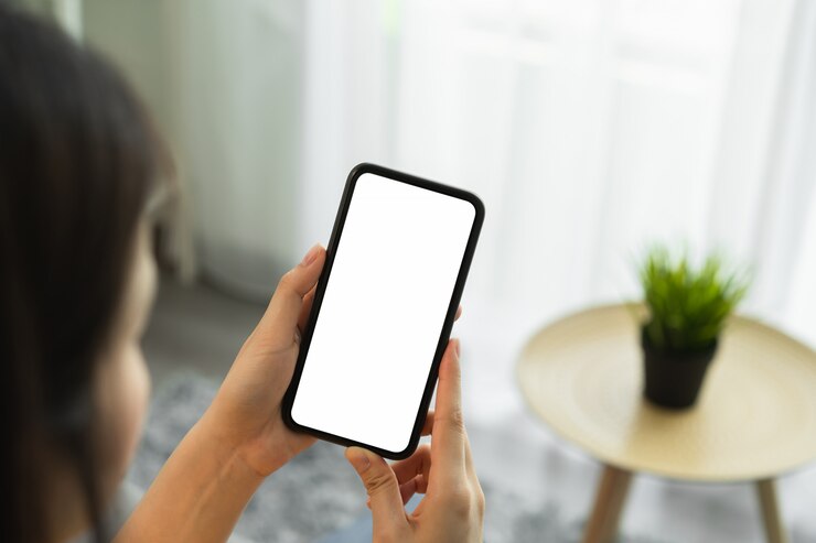Derida su dello smartphone della tenuta della mano della donna e dello schermo in bianco commovente.