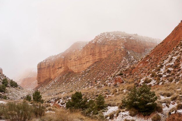 Deserto con montagne marroni parzialmente coperte di neve.
