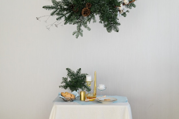 Design estetico per natale con ghirlanda sospesa in pino nobilis, candele e decorazioni da tavola.