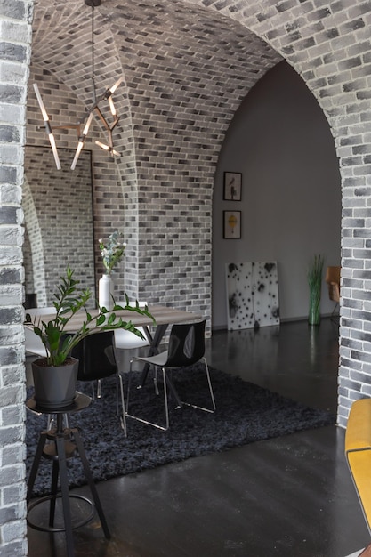 Design moderno e lussuoso di un appartamento brutale con archi nello stile di un castello medievale con accenti luminosi disposizione libera zona cucina salotto e zona pranzo