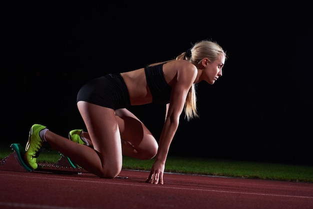 design pixelato di una velocista donna che lascia i blocchi di partenza sulla pista di atletica. Vista laterale. inizio esplosivo