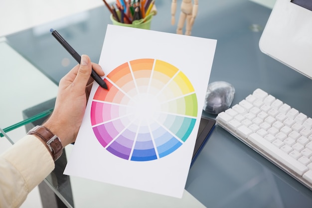 Designer che lavora alla scrivania usando una ruota dei colori