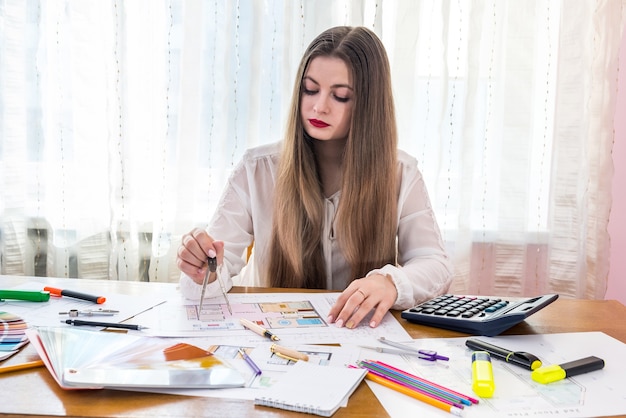 Designer che lavora con la bussola sul piano della casa